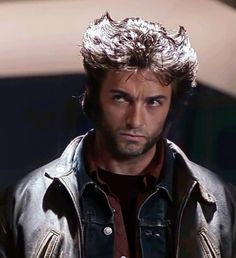 a man in a leather jacket looking at the camera