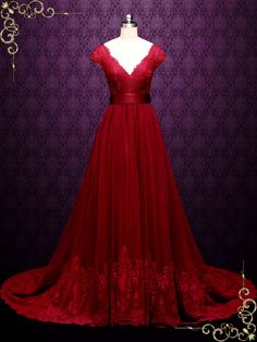 a red dress is on display in front of a purple wall with an ornate design