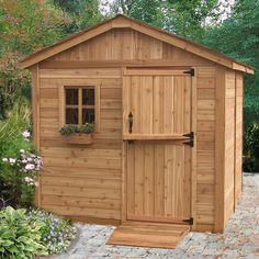 a small wooden shed with windows on the side and flowers growing in the window boxes