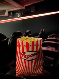 a bag of popcorn sitting on top of a table in front of a row of seats