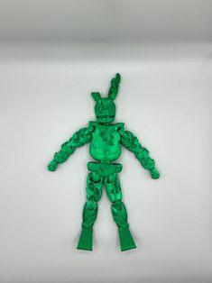 a green plastic toy that looks like an alien