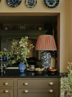 an image of a kitchen setting with flowers and plates on the wall above the counter