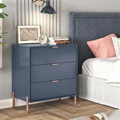 a bedroom with a blue dresser next to a bed