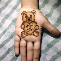 a child's hand with a bear drawn on it and the words mom dad