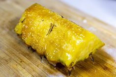 a piece of pineapple sitting on top of a wooden cutting board