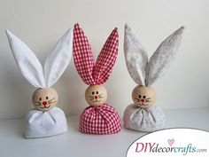 three wooden bunnies in the shape of rabbits with red and white checkered bows