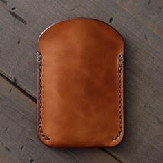 a brown leather case sitting on top of a wooden floor