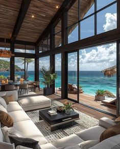 a living room filled with lots of furniture and large windows overlooking the ocean in front of it