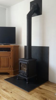 a living room with wood floors and a black stove