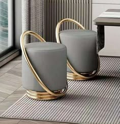 two gray stools sitting next to each other on a rug