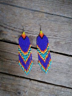 two pairs of beaded earrings hanging from wooden planks