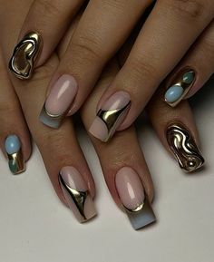 a woman's hands with gold and blue nail polishes on their nails,