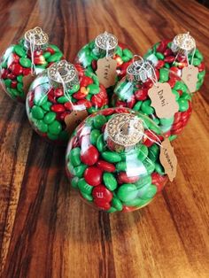 three christmas ornaments with candy in them on a table