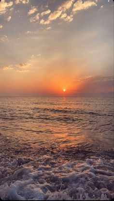 the sun is setting over the ocean with waves