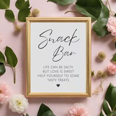 a framed sign that says snack bar on it next to pink flowers and green leaves