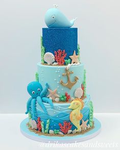 a three tiered cake decorated with an octopus and sea animals