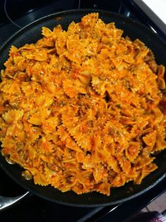 a pan filled with pasta and sauce on top of a stove