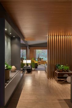 a long hallway with wood paneling and plants on the side tables in front of it