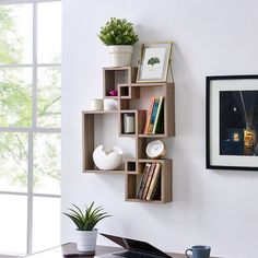 a laptop computer sitting on top of a wooden desk next to a book shelf filled with books