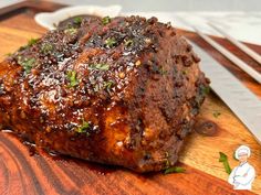 a piece of meat sitting on top of a wooden cutting board