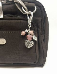 a purse with a keychain and charms on it's front pocket is shown