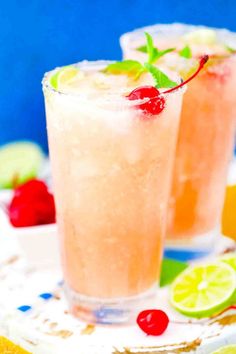 two glasses filled with watermelon lemonade and garnished with cherries