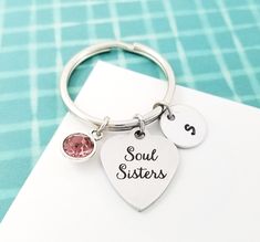 a keychain with two charms that say soul sisters and one has a heart on it