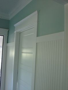 an empty room with white doors and green walls