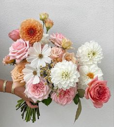 a person holding a bouquet of flowers in their hand