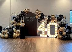 a large number sign made out of balloons in the middle of a room with wooden floors