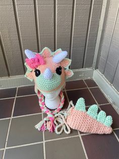 a crocheted stuffed animal next to a pair of slippers on the floor