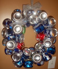 a bunch of soda cans that are in the shape of a wreath with words on it