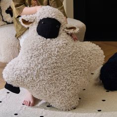 a child is playing with a stuffed sheep