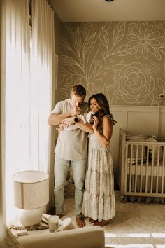 a man and woman standing next to each other in front of a baby crib