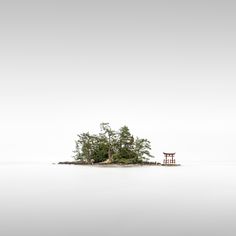 an island in the middle of water with a chair on it