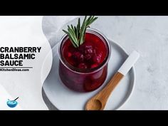 cranberry balsamic sauce on a white plate next to a wooden spoon