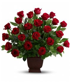 a vase filled with lots of red roses