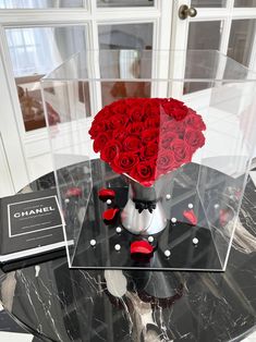 a vase filled with red roses sitting on top of a table