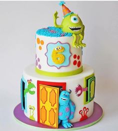 a three tiered cake with monsters on the front and sides, decorated in bright colors