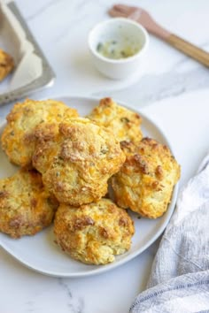 some biscuits are on a white plate next to a cup