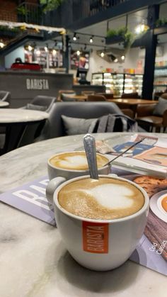 two cups of cappuccino sitting on top of a table in a restaurant