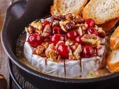 a baked dessert with cherries and nuts in a cast iron skillet