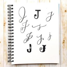 a spiral notebook with the letters j and j in cursive writing on it