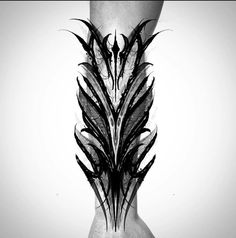 a black and white photo of a person's leg with feathers on it in the shape of a feather