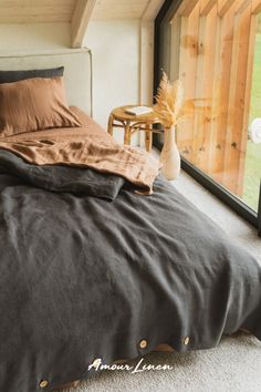 a bed sitting in a bedroom next to a window with a vase on top of it