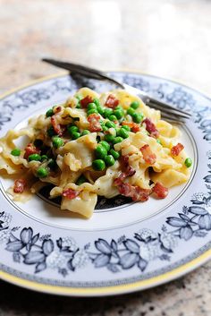 a white plate topped with pasta and peas