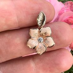 Pua'a (Sparkling Flower) pendant with a Diamond in the center and leaf bail. Approx. 16mm wide. Available in: 14K Yellow Gold w/ .10ct Diamond [PD4-Y10D-V]14K Yellow Gold w/ .12ct Diamond [PD4-Y12D-V]14K Pink Gold w/ .12ct Diamond [PD4-P12D-V] Pictured with 14K Yellow Gold 1.5mm 16'' Rope Chain (RC29). All Sales Final. No returns or exchanges. Chain sold separately. Hawaiian Heirloom Jewelry, Hawaiian Plumeria, Heirloom Jewelry, Band Necklace, Initial Gifts, Heirlooms Jewelry, Womens Wedding Bands, Initial Pendant, Diamond Bracelets