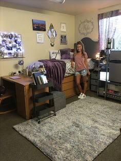 a young woman standing in her dorm room