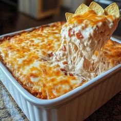 a close up of a casserole dish with cheese and tortilla chips