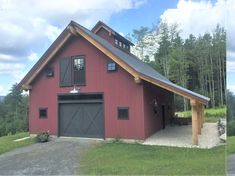 a red barn with a black garage door and windows